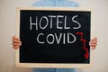 Hotels covid crisis. Coronavirus concept. Boy hold inscription on the board