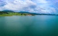 Hotels on shores of lake with reflection of mountains Rhodope against cloudy sky. Panorama, top view Royalty Free Stock Photo