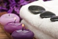 Hotstones on towel with purple candles (1) Royalty Free Stock Photo