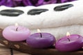 Hotstones on towel with purple candles (2) Royalty Free Stock Photo