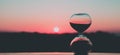 Hour glass against the background of the rising sun and the pink sky, art photography Royalty Free Stock Photo