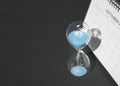 Hour glass and calendar on black tabletop background