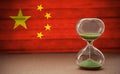 Hourglass on the background of the Chinese flag, the concept of time and countries, space for text Royalty Free Stock Photo