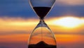 Hourglass on the background of a sunset. The value of time in life. An eternity