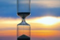 Hourglass on the background of a sunset. The value of time in life. An eternity