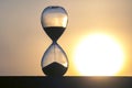 Hourglass on the background of a sunset. The value of time in life. An eternity Royalty Free Stock Photo