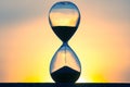 Hourglass on the background of a sunset. The value of time in life. An eternity Royalty Free Stock Photo