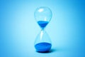 Hourglass with blue sand on blue background Royalty Free Stock Photo