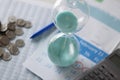 Hourglass calendar and coins lie on table closeup Royalty Free Stock Photo