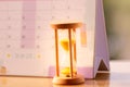 Hourglass on calendar concept for time slipping away for important appointment date.