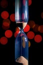 Hourglass in the center. Sand strews down on christmas background, bokeh red christmas lights Royalty Free Stock Photo