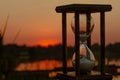 Hourglass counts down the time on the sunset pond Royalty Free Stock Photo