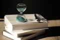 Hourglass countdown with books and a pen Royalty Free Stock Photo