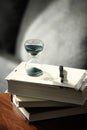 Hourglass countdown with books and a pen Royalty Free Stock Photo