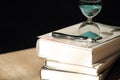 Hourglass countdown with books and a pen Royalty Free Stock Photo