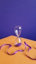 hourglass and curled purple ribbon on an orange-purple background. a symbol of nothingness. infinity symbol. Royalty Free Stock Photo