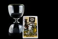 Hourglass with Death Tarot Card Isolated on a Black Background