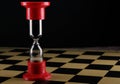 Hourglass on empty chess board, shallow DOF with selective focus