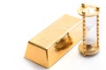 Hourglass and fine gold bullion on white background.