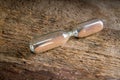 An hourglass flask on a rough wooden surface.