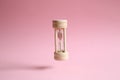 Hourglass floating on pink background