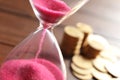 Hourglass with flowing sand on table. Time management