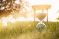 Hourglass in the grass time during sunset. vintage style.