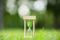 Hourglass on green grass field , spring time