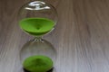 Hourglass with green sand, life time passing concept Royalty Free Stock Photo