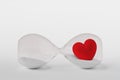 Hourglass with heart lying on white background - Concept of time and love Royalty Free Stock Photo