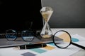 Hourglass, laptop and charts close-up, business and time management concept Royalty Free Stock Photo