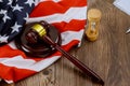 Hourglass measuring the US judge legal office with judge's gavel on American flag table Royalty Free Stock Photo