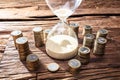 An Hourglass Near Stack Of Coins Royalty Free Stock Photo