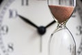 Hourglass and old alarm clock. Sand clock on the background of the dial