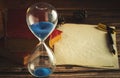 Hourglass and old books with old paper and pen. Royalty Free Stock Photo