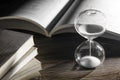 Hourglass and open book on wooden table Royalty Free Stock Photo
