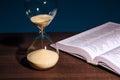 Hourglass and open Holy Bible Royalty Free Stock Photo