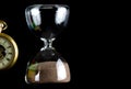 Hourglass and Partial View of Pocket watch Isolated on Black Royalty Free Stock Photo