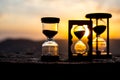 Hourglass Passing of Time Lapse Clouds. An hourglass in front of a bright blue sky with puffy white clouds passing. Time concept. Royalty Free Stock Photo