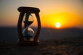 Hourglass Passing of Time Lapse Clouds. An hourglass in front of a bright blue sky with puffy white clouds passing. Time concept. Royalty Free Stock Photo