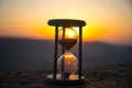 Hourglass Passing of Time Lapse Clouds. An hourglass in front of a bright blue sky with puffy white clouds passing. Time concept. Royalty Free Stock Photo