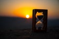 Hourglass Passing of Time Lapse Clouds. An hourglass in front of a bright blue sky with puffy white clouds passing. Time concept.