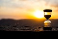 Hourglass Passing of Time Lapse Clouds. An hourglass in front of a bright blue sky with puffy white clouds passing. Time concept. Royalty Free Stock Photo