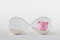 Hourglass with piggy bank lying on white background - Concept of economy savings and stopping time