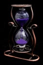 Hourglass with purple sand in a metal frame