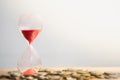 Hourglass red sand and stack of coins. Royalty Free Stock Photo