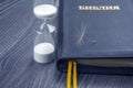 Hourglass and Russian bible with dandelion seed. sow the seed of faith in God. Christianity and religion