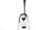 Hourglass and Sand fly in mid air, add more sand of time on gold sand over white background. Black hourglass show more time