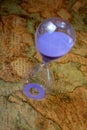 Hourglass, sandglass, sand timer, sand clock on old treasure world map