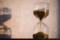 Hourglass with shadow on wall. Time passing concept for business deadline, urgency and running out of time. Sandglass Royalty Free Stock Photo